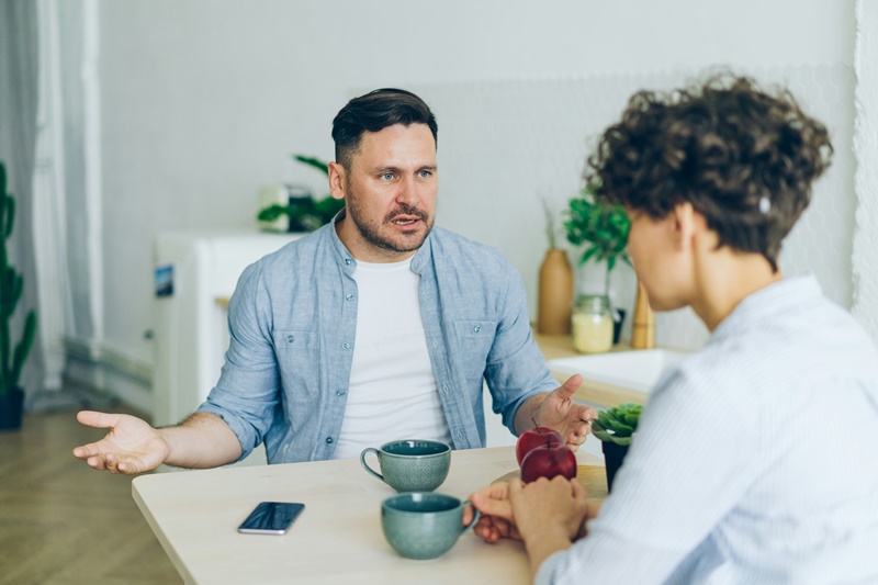 male and female sitting at a table arguing